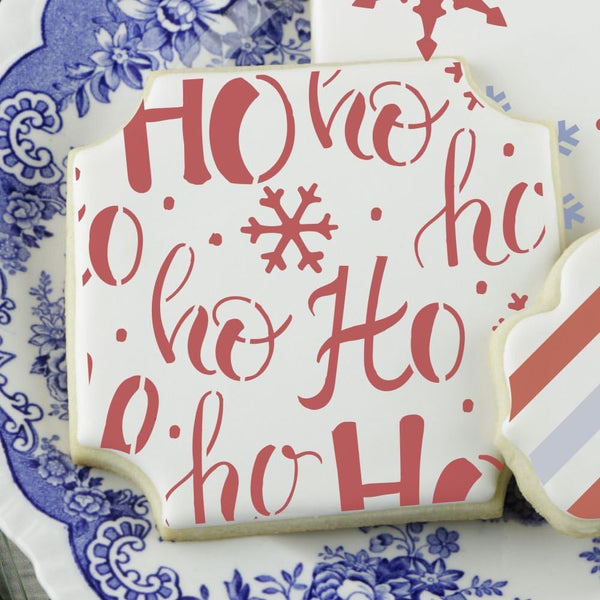 Decorated Christmas cookie with 'Ho Ho Ho' design on festive plate, showcasing holiday-themed stencil art.