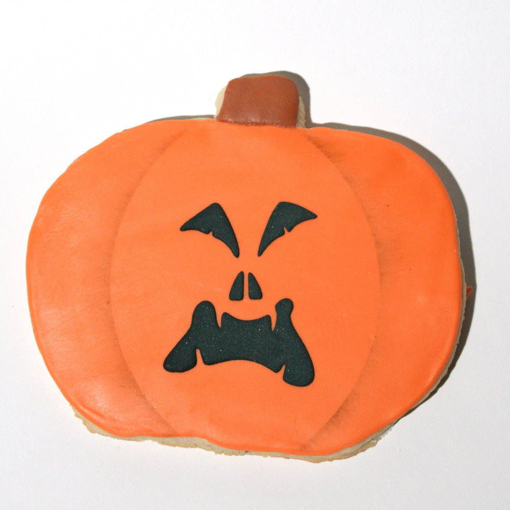 Jack-O-Lantern cookie with orange icing and black facial features, perfect for Halloween decoration.
