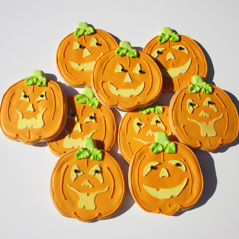 Set of decorated pumpkin cookies withHalloween faces, perfect for festive treats and celebrations.