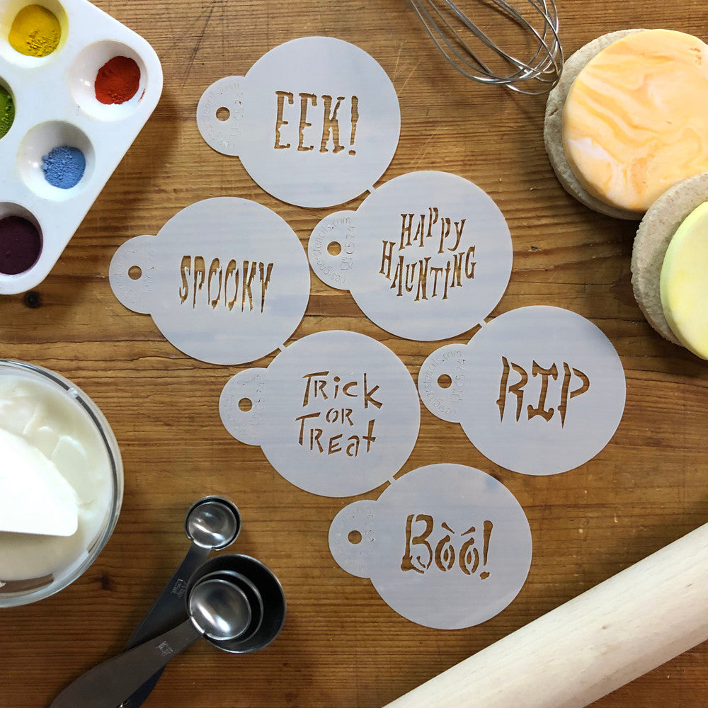 Set of Halloween cookie stencils featuring sayings like 'Boo,' 'Trick or Treat,' and 'Spooky' on a wooden table.