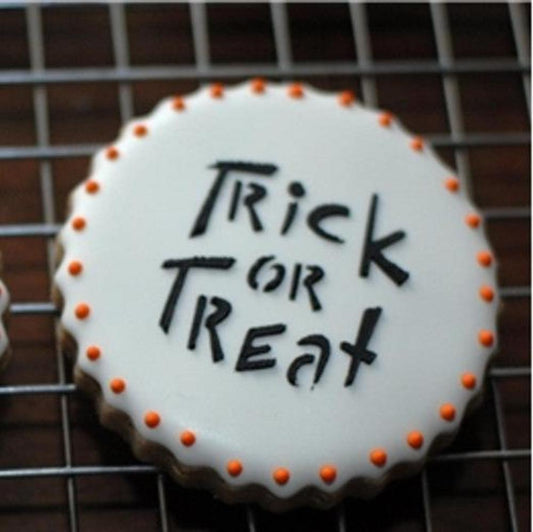 Halloween cookie with 'Trick or Treat' decoration, featuring orange accents and a round shape.