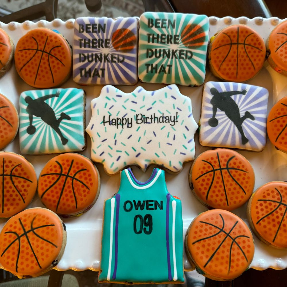 Colorful basketball-themed cookies for a birthday party, featuring basketball designs and a personalized jersey.
