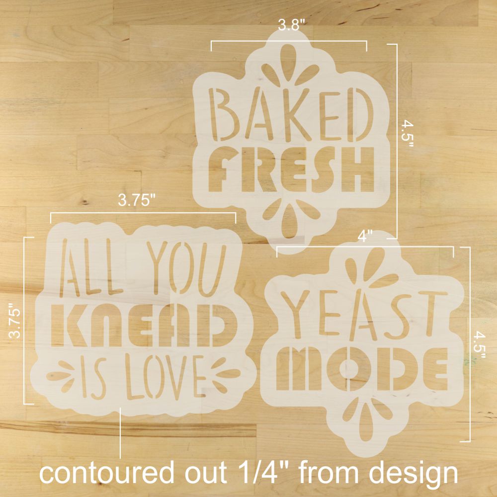 Three stencils with text 'BAKED FRESH', 'ALL YOU KNEAD IS LOVE', and 'YEAST MODE' on a wooden surface.