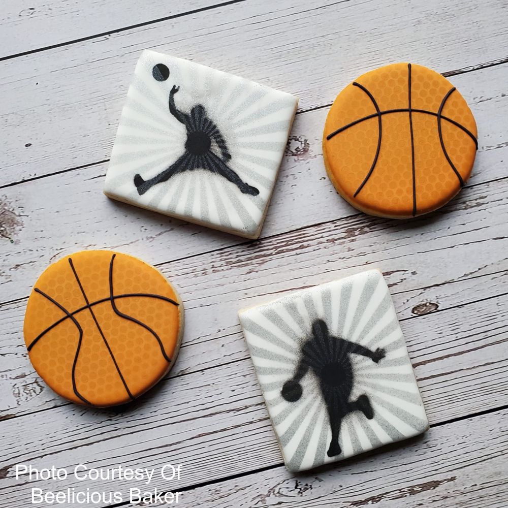 Basketball-themed cookies featuring stencil designs in vibrant orange and black, ideal for parties and celebrations.