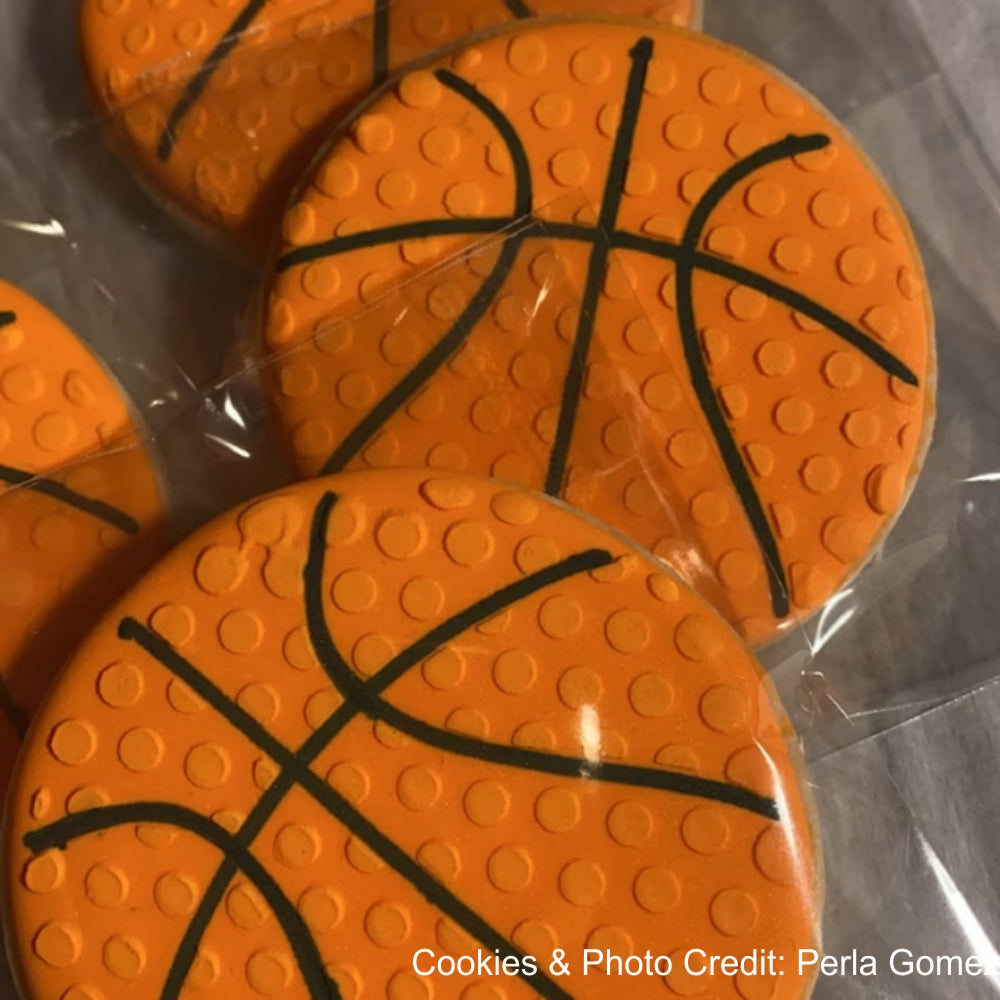 Colorful basketball-shaped cookies featuring an orange design with black lines, ideal for themed parties.