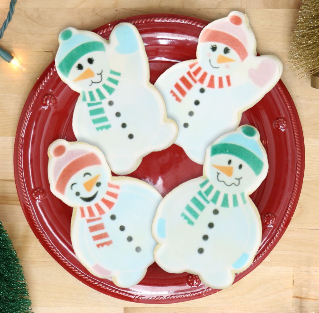 Deliciously decorated snowman cookies on a red plate, perfect for holiday celebrations and cookie decorating fun!