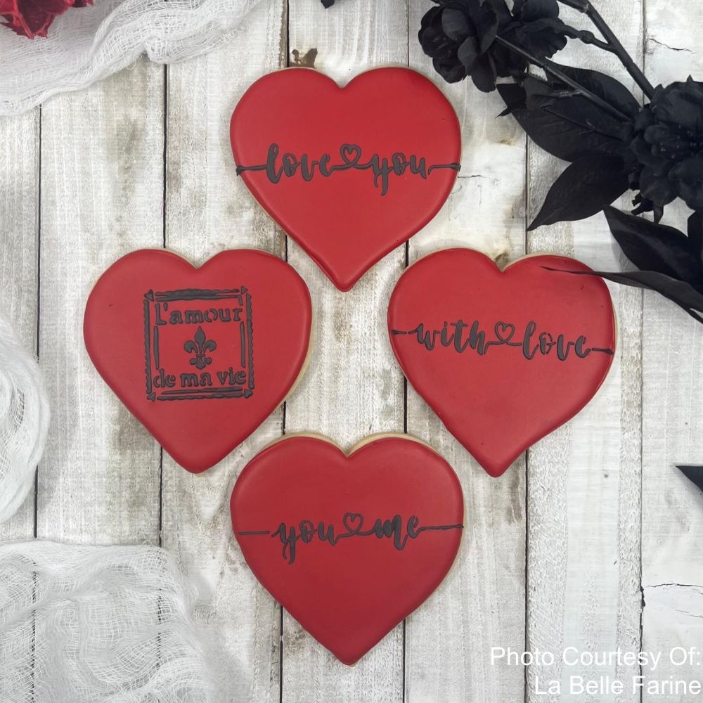 Heart shaped cookies decorated using the Love Script Cookie Stencil