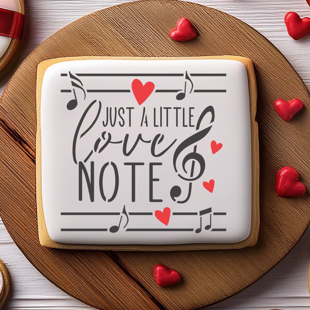 Valentine cookie with musical stencil reading 'Just a Little Love Note' surrounded by heart decorations.