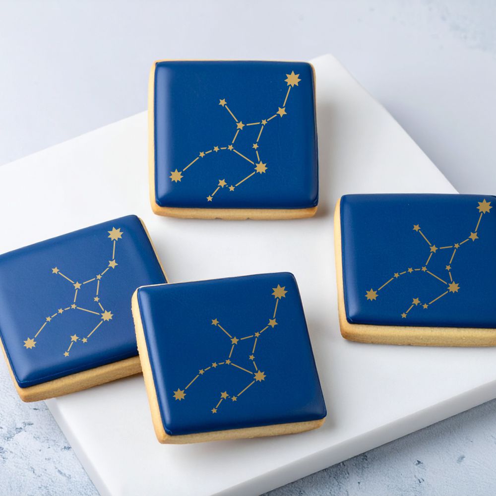 Cookies with blue icing and stenciled gold Virgo star constellation.