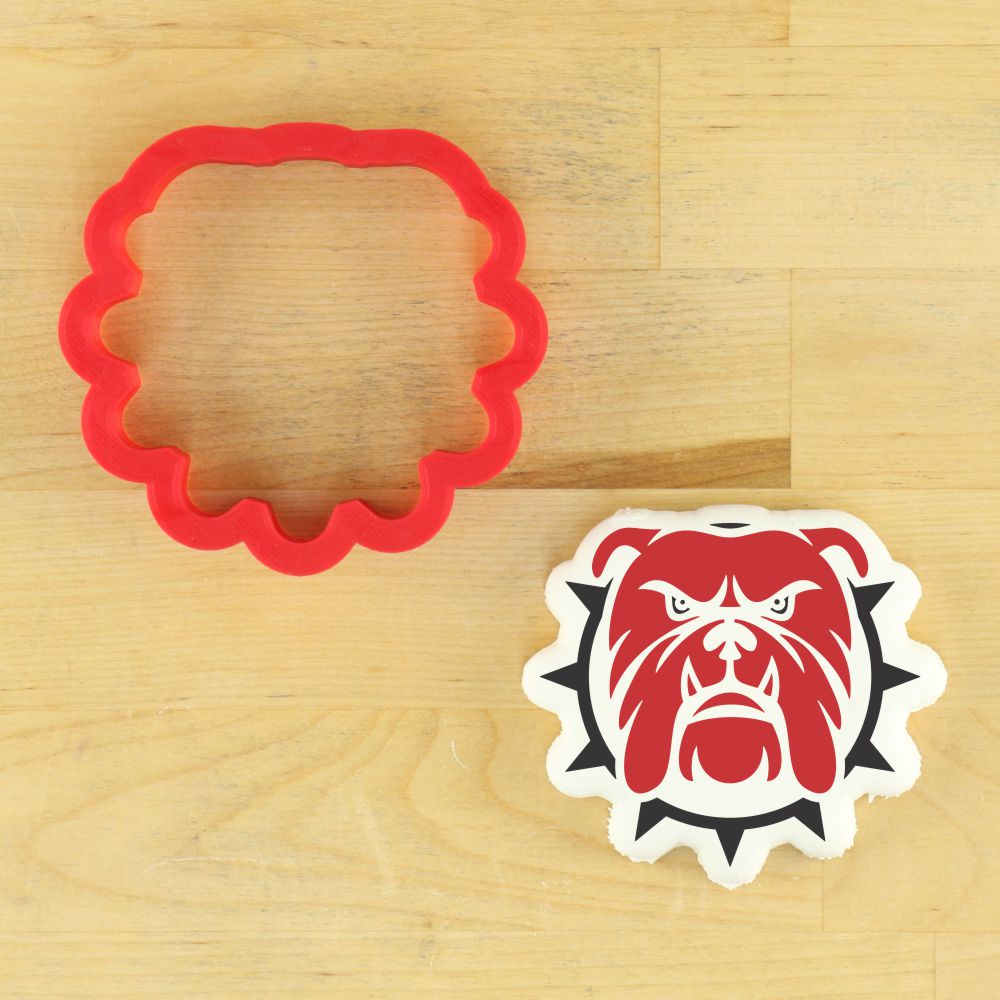 Bulldog mascot cookie stencil and matching red cookie cutter on a wooden surface.