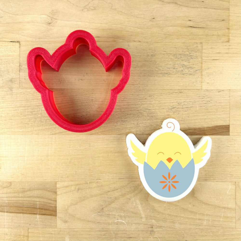 Easter Chick in Egg cookie stencil and matching cutter on wooden background.