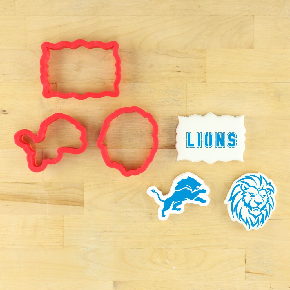 Lion mascot cookie stencil set with red cookie cutters and lion-themed stencils on a wooden surface.