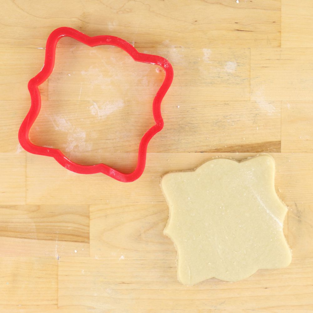 Red cookie cutter and shaped cookie on wooden surface for BBQ Beer and Freedom Project Kit.