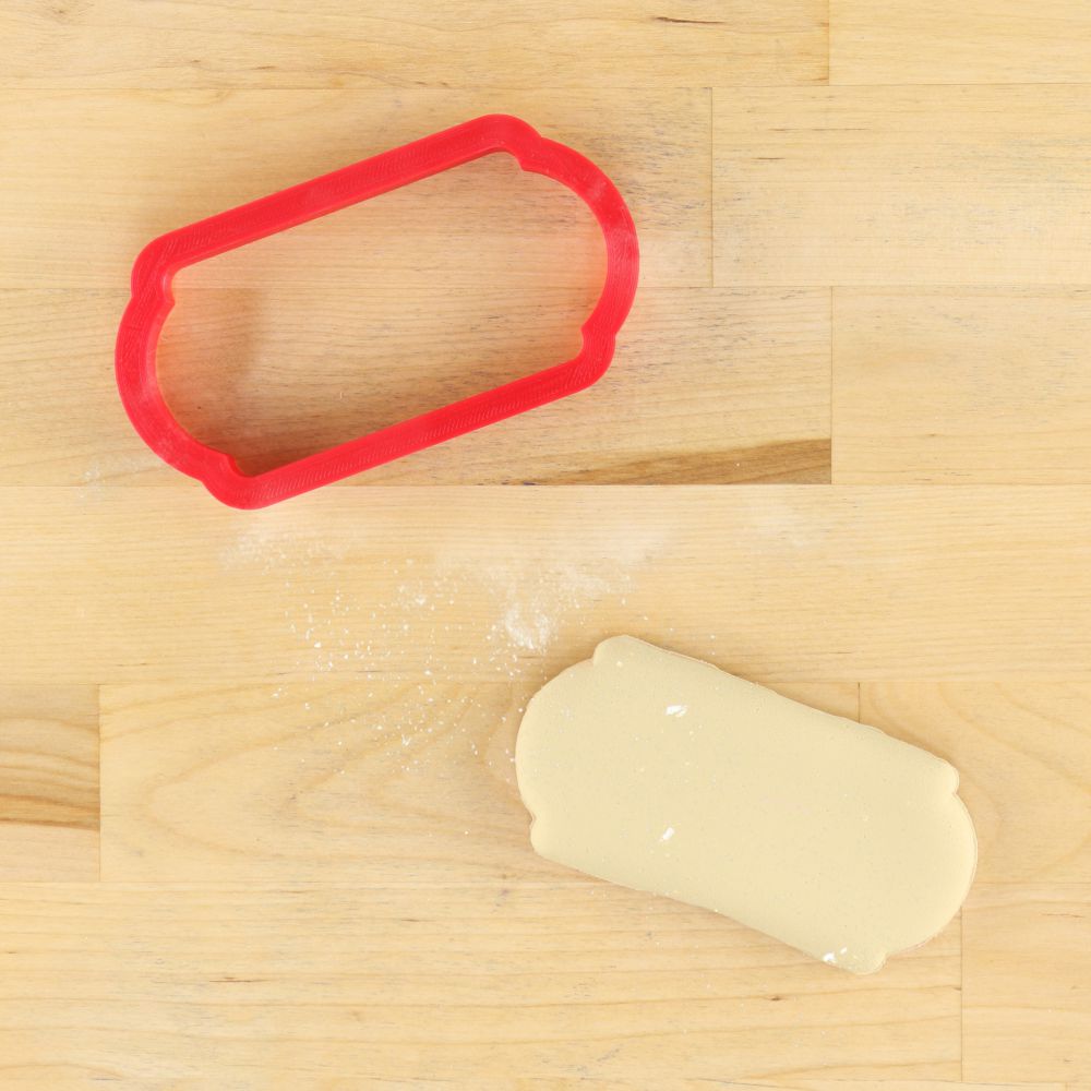 Red cookie cutter and freshly rolled dough on a wooden surface for BBQ Beer and Freedom decorating kit.
