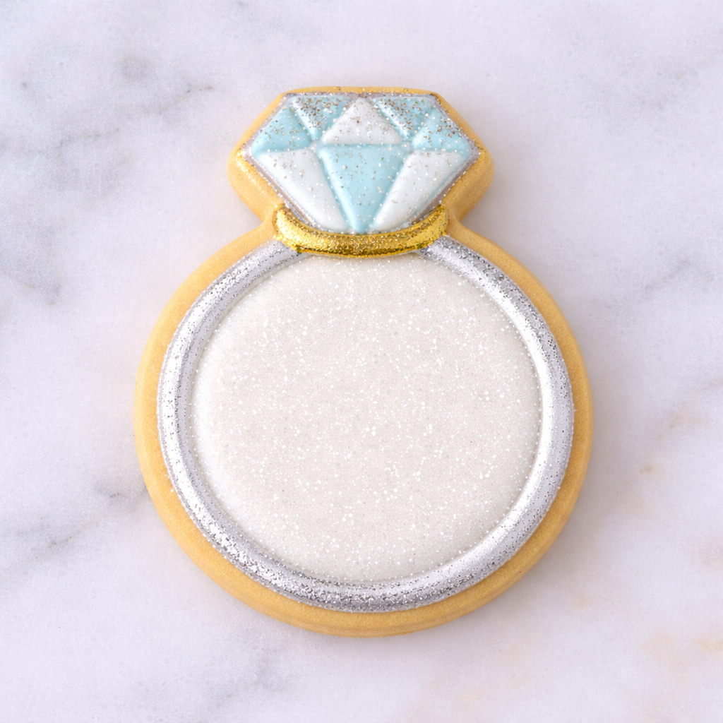 Cookie shaped like a diamond ring on a marble surface