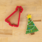 Christmas Tree Cookie Cutter next to a Christmas Tree Cookie decorated with icing and topped with edible candy
