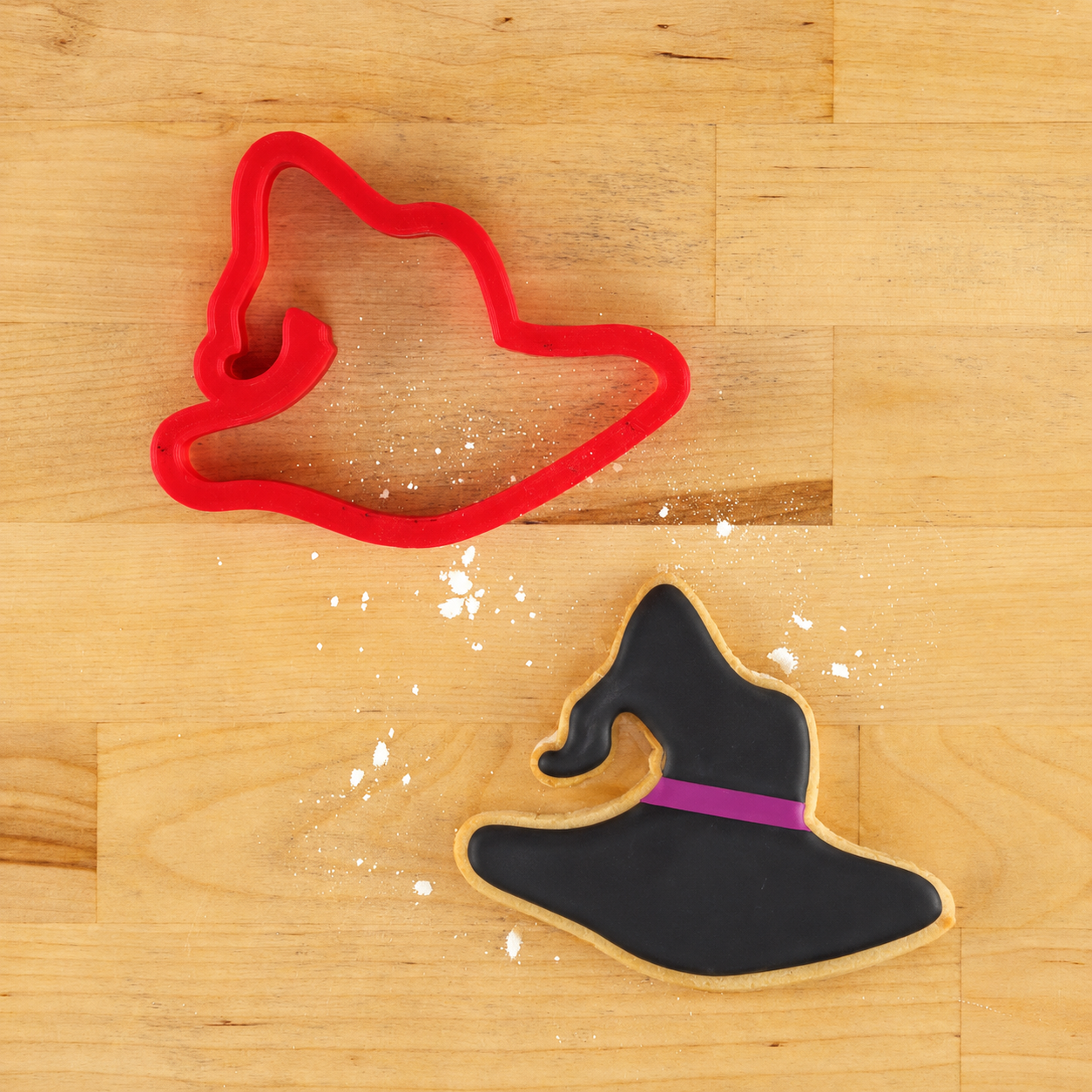 Witch Hat Cookie Cutter and a Witch Hat shaped cookie that is iced in black.