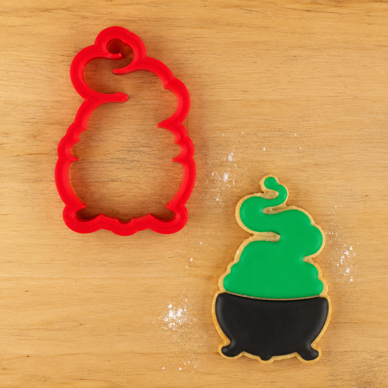 Witch Cauldron Cookie Cutter with a cauldron shaped cookie iced and decorated for halloween