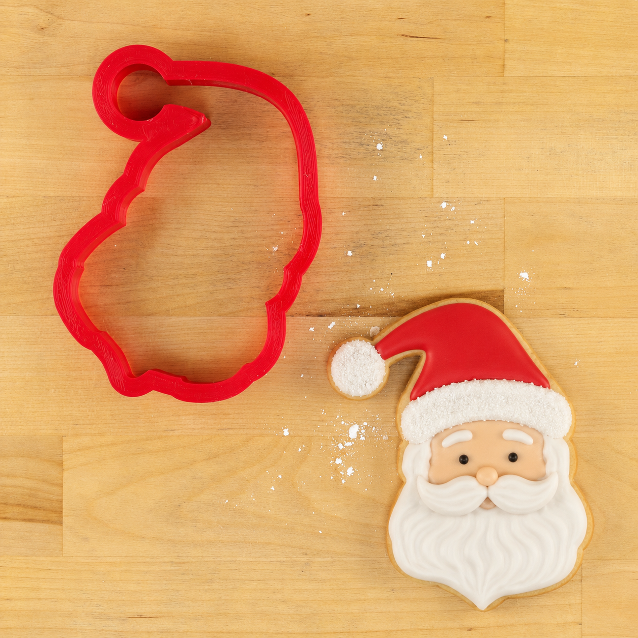 3D Printed Santa Cookie Cutter next to a Santa Face-shaped cookie decorated for Christmas