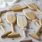 Decorative cookies shaped like champagne glasses on a marble surface.