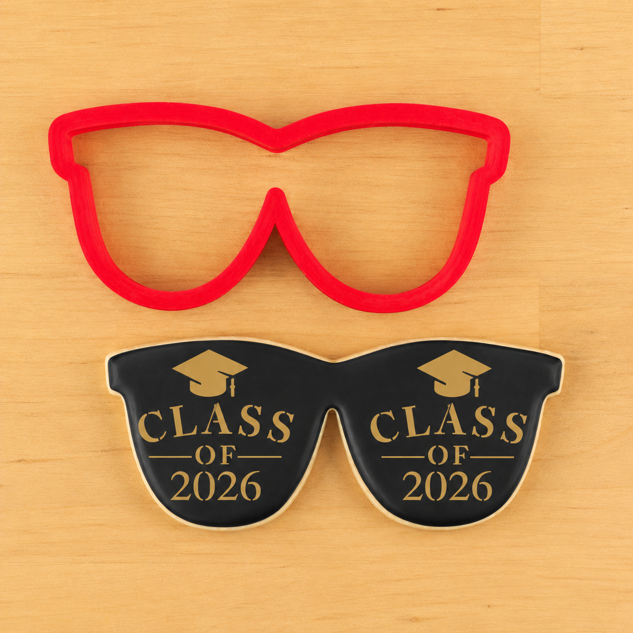 Sunglass shaped cookies iced black and stenciled with graduation cookie stencils