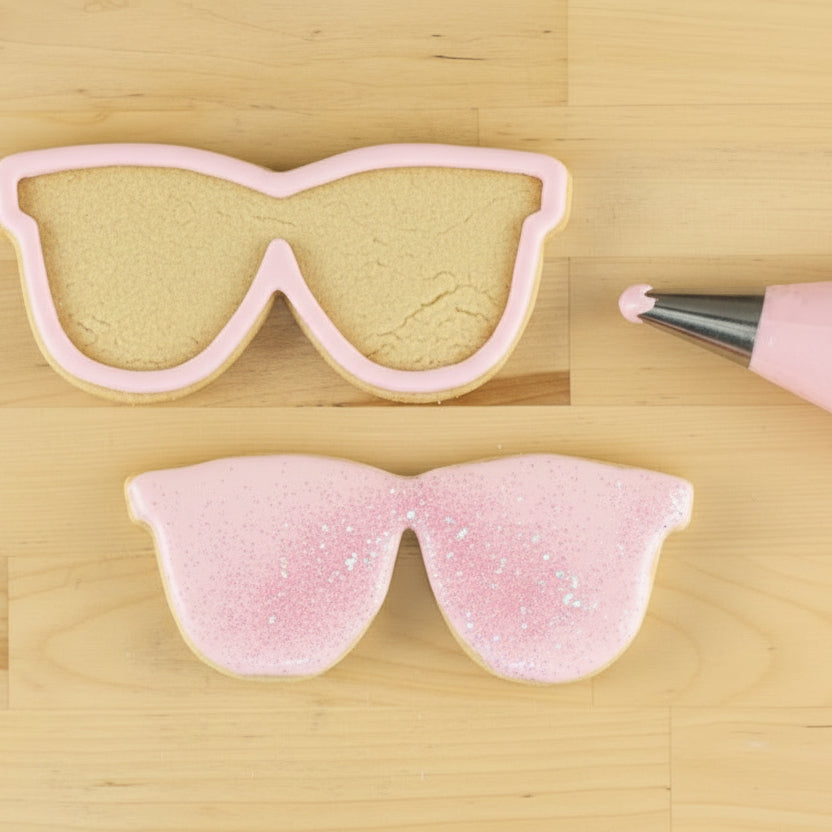 Sunglasses Shaped Cookies being iced in pink icing