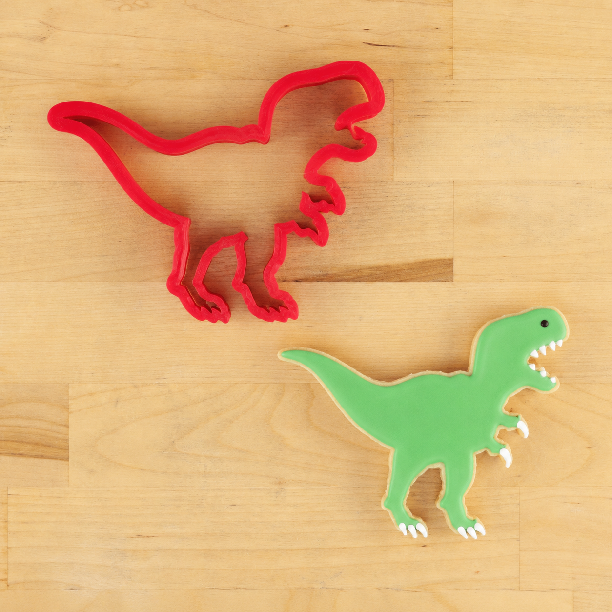 T-Rex cutter next to a t-rex shaped cookie