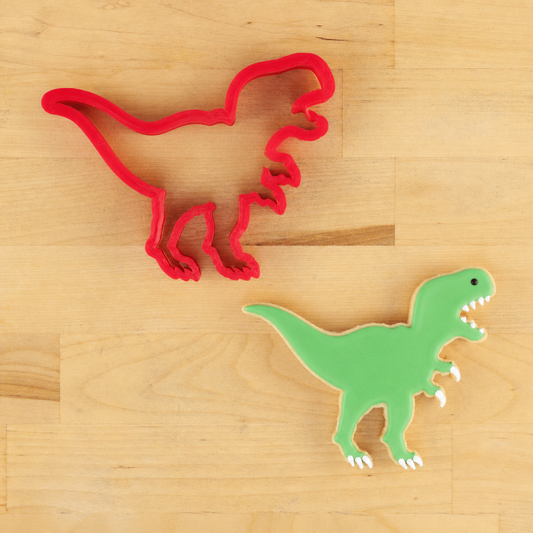 T-Rex cutter next to a t-rex shaped cookie