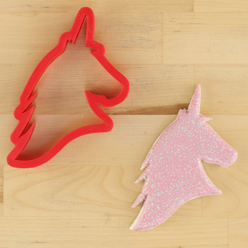 Unicorn Cookie Cutter and cookie flooded with pink icing and dusted with edible glitter