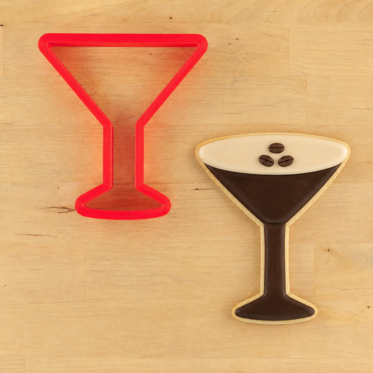 Martini Glass cookie cutter with a matching espresso martini-shaped cookie next to it.
