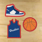 Basketball themed cookies decorated with jersey, sneaker, and basketball cookie cutters