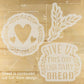 Decorative stencils with heart, leaf, and 'Give us this day our daily bread' design on a wooden surface.
