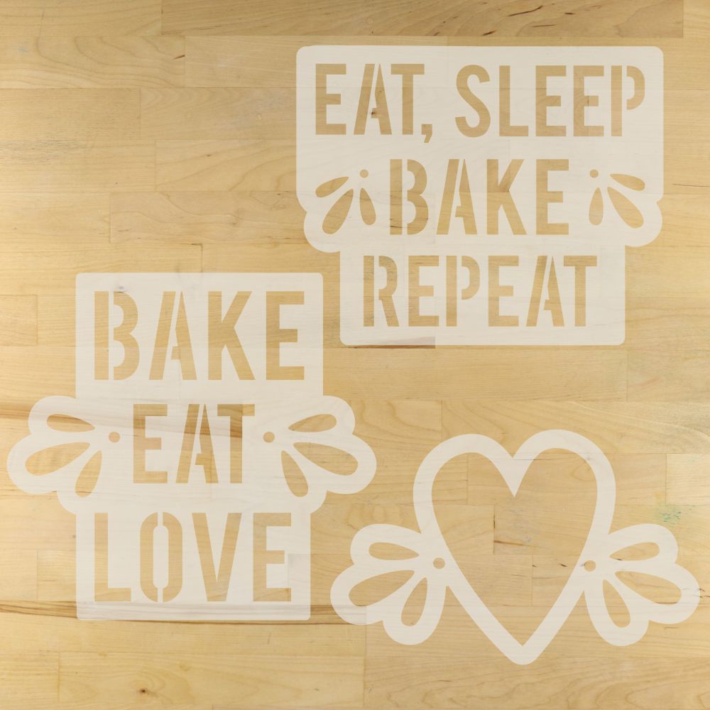 Decorative artisan bread stencils with text and a heart design on a wooden surface