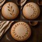 Flour dusted sourdough loaf with laurel wreath bread stencil