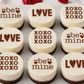 Small round cheese with Valentine's Day text on a white plate.