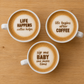 Three coffee cups with latte art and text on a wooden surface