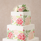 Three-tiered wedding cake with floral patterns on a neutral background