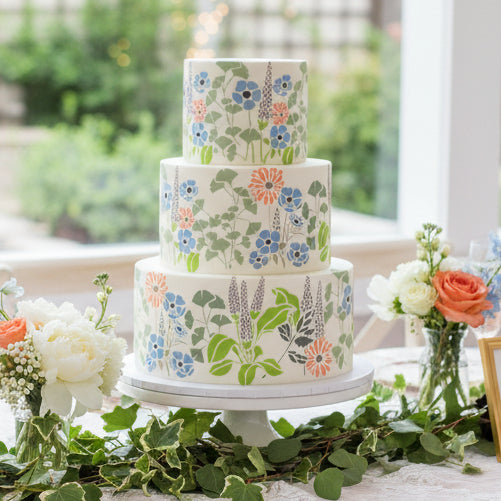 Floral stencil applied to a three-tiered bridal shower cake