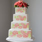 Decorative design of stylized flowers and leaves in coral and green on a white cake
