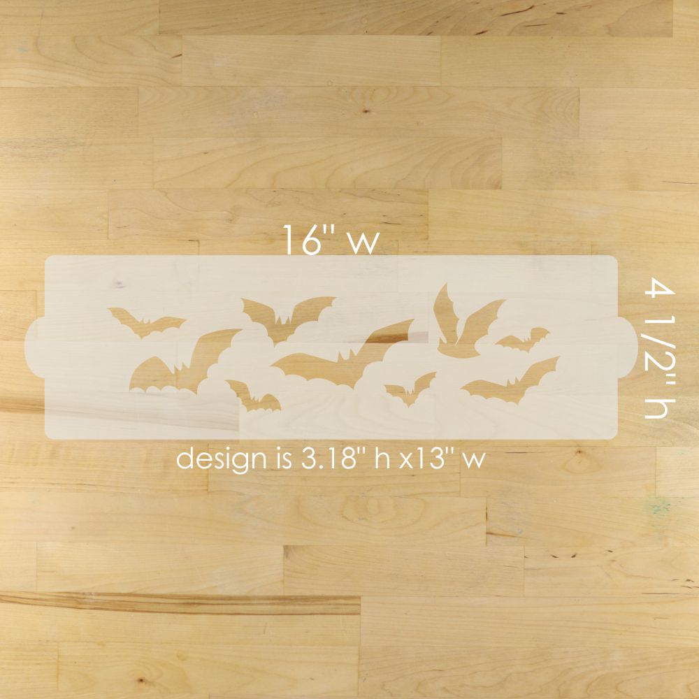 Halloween-themed stencil with bat designs on a wooden surface, showing dimensions.
