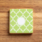 Green and white patterned stenciled onto a cookie on a wooden surface