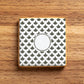 Square iced cookie stenciled with a scale pattern on a wooden surface