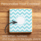 Cookie with blue and white zigzag pattern on a wooden surface, promoting customization.