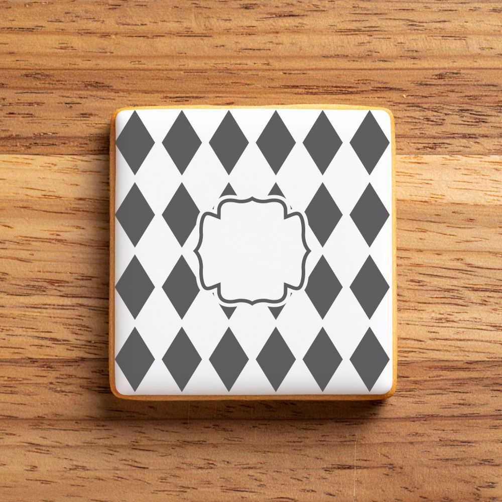 Square iced cookie with gray diamond pattern on a wooden surface