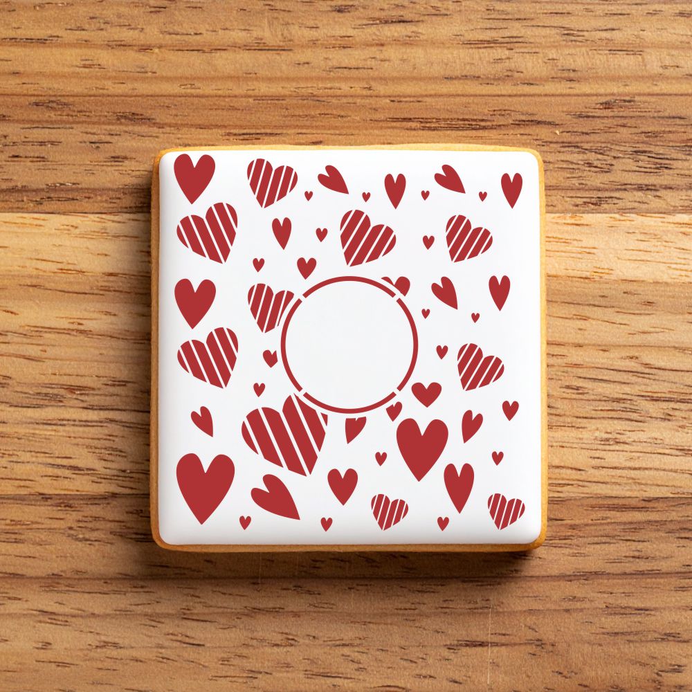 Square cookie stenciled with a red heart pattern