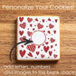 Cookie with red heart pattern on a wooden surface, promoting customization.