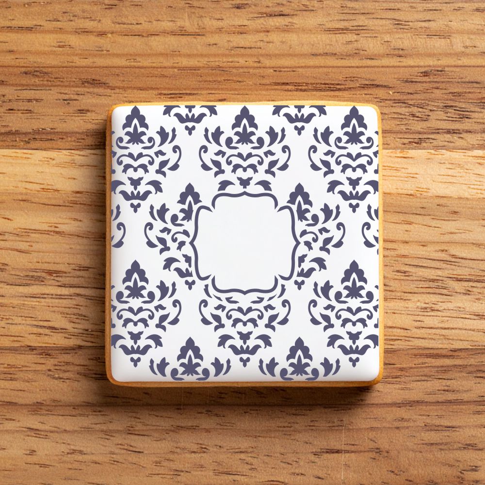 Decorative iced cookie with a blue and white pattern on a wooden surface