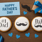 Mockup of the Father's Day Round Cookie Stencil 3 Pc Set on three round cookies laying on a table decorated for Father's Day.