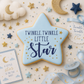 Star-shaped cookie with 'Twinkle, Twinkle Little Star' text on a baby-themed background
