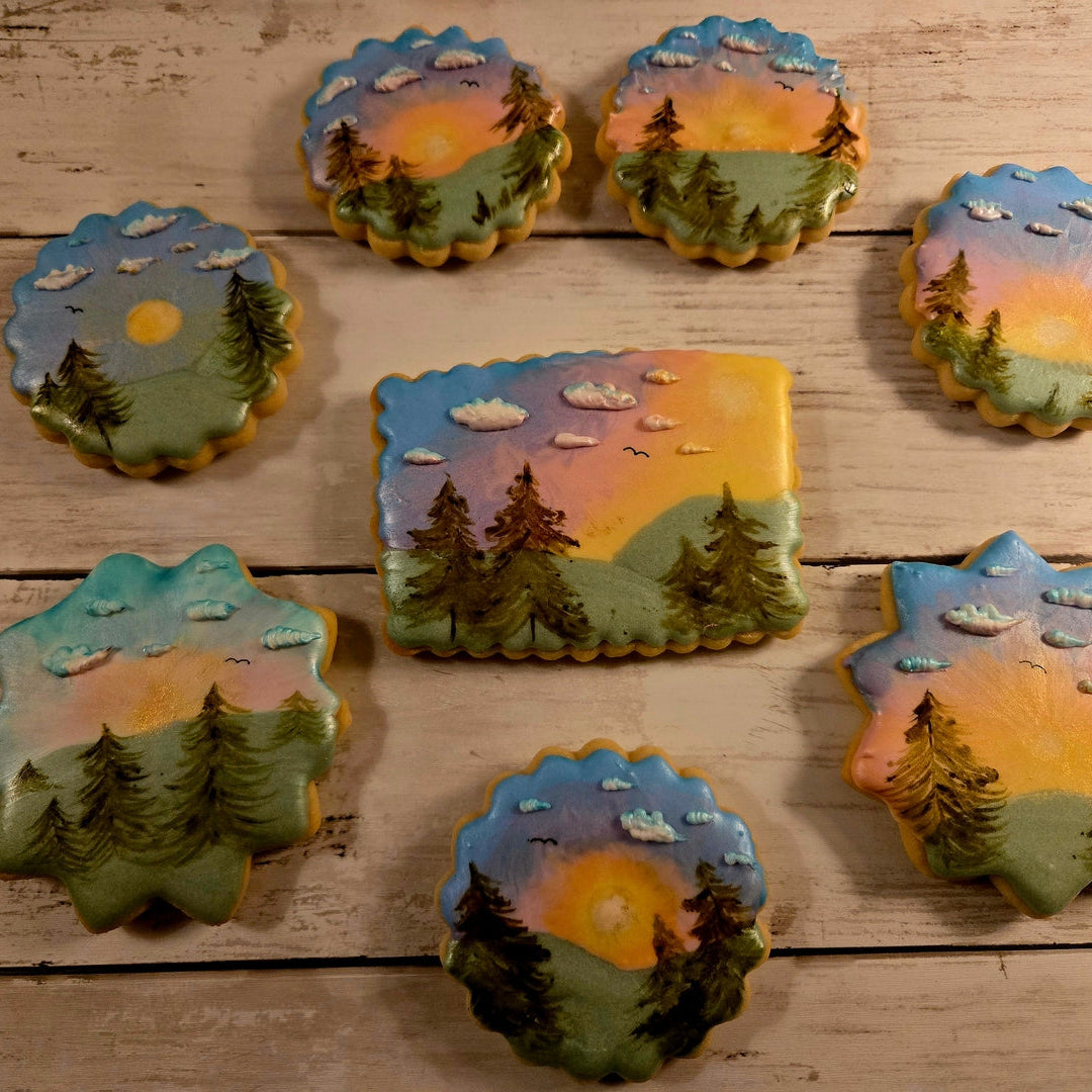 Decorative cookies with scenic designs on a wooden surface